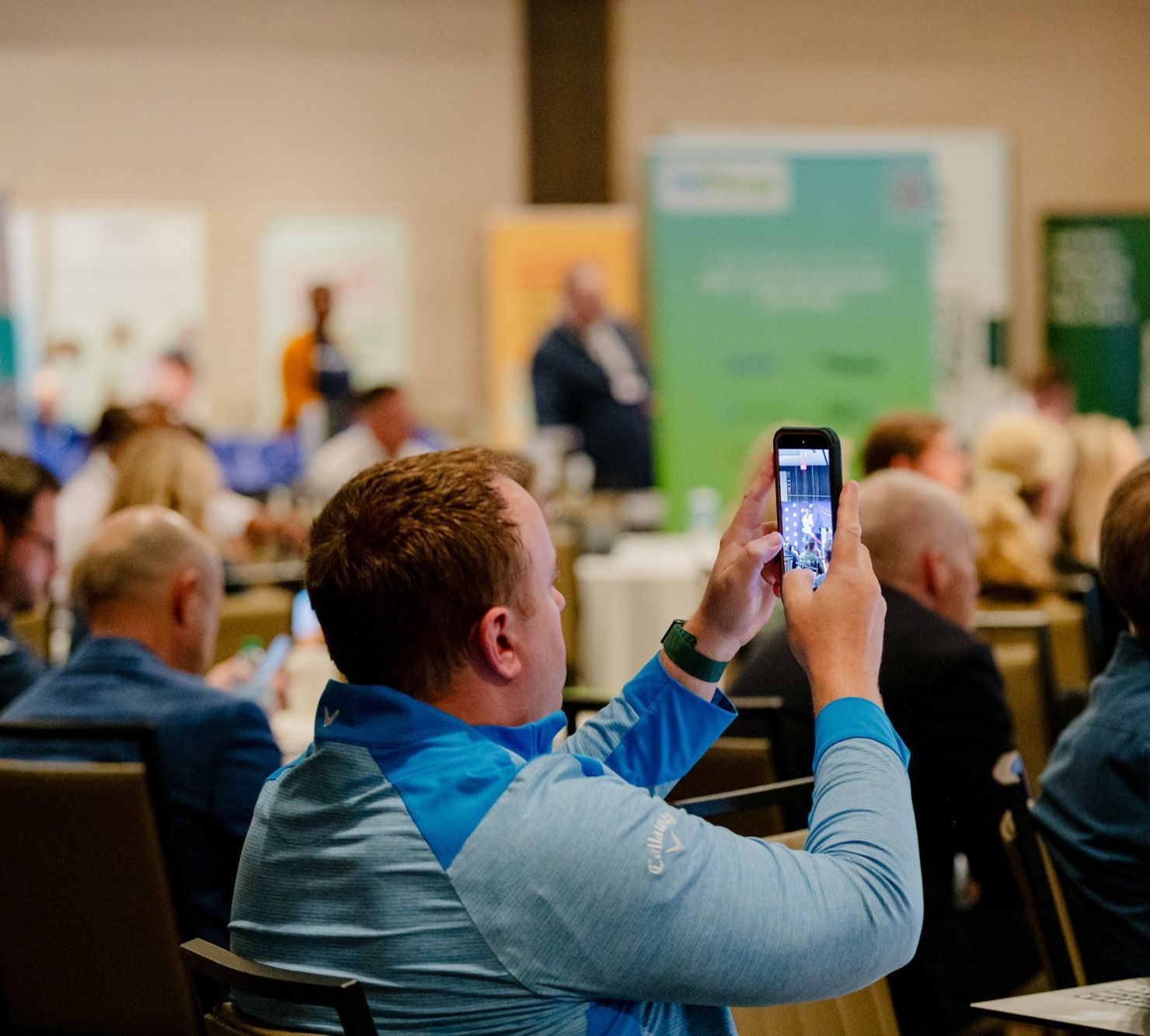 An attendee filming the talk on his phone